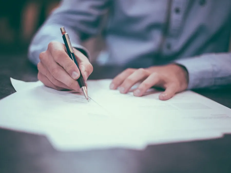 Signature d'un document administratif sur un bureau